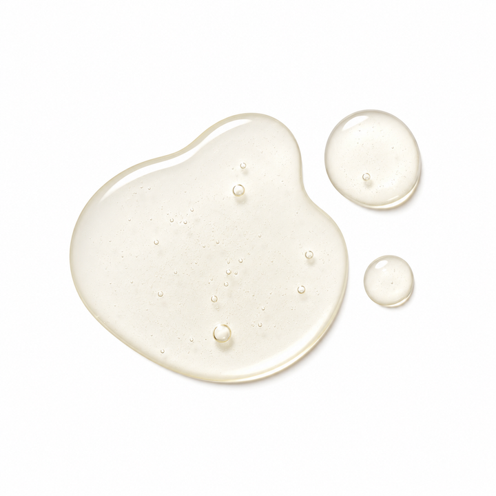Three translucent droplets of clear, glossy gel or serum on a solid white background, including one large irregular puddle and two smaller round droplets.