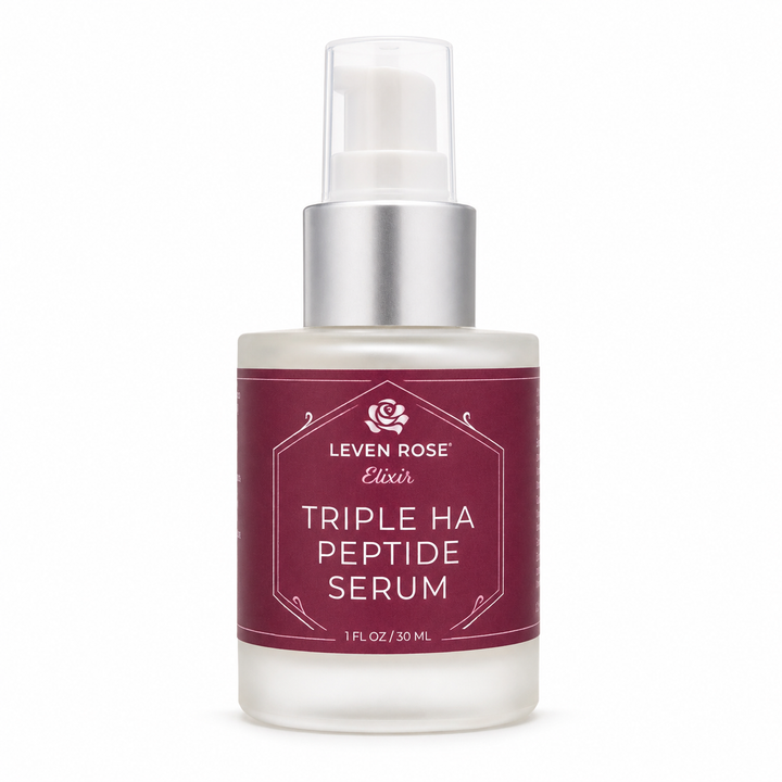 A bottle of Leven Rose Elixir Triple Ha Peptide Serum with a frosted glass body, a metallic silver pump collar, and a deep burgundy label with white text.