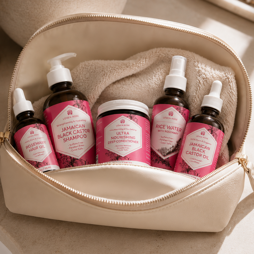 An open beige zip pouch on a light surface holding five hair-care bottles and a jar from Lemon & Rose. The pouch lining and labels are pink, and the bottles are dark amber with white caps.