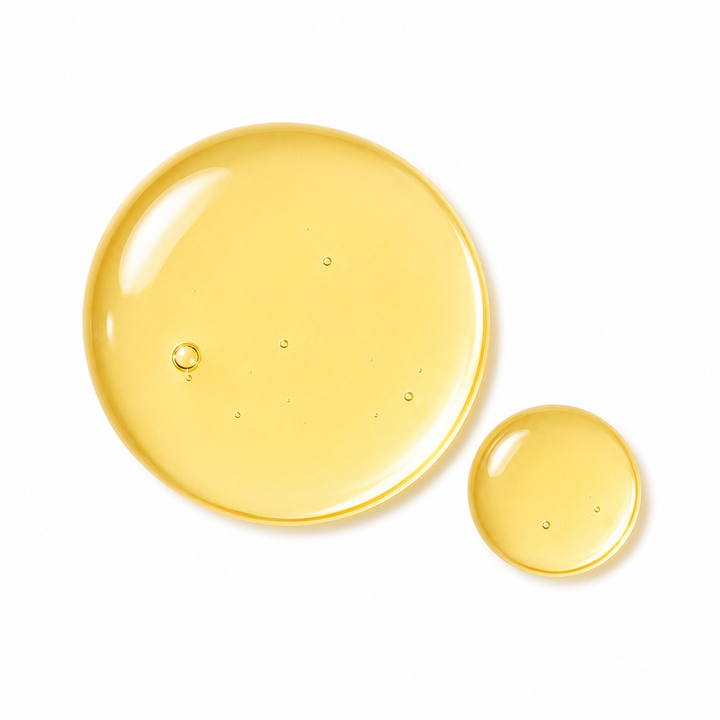 Two translucent golden-yellow liquid droplets on a clean white background, one large and one small.
