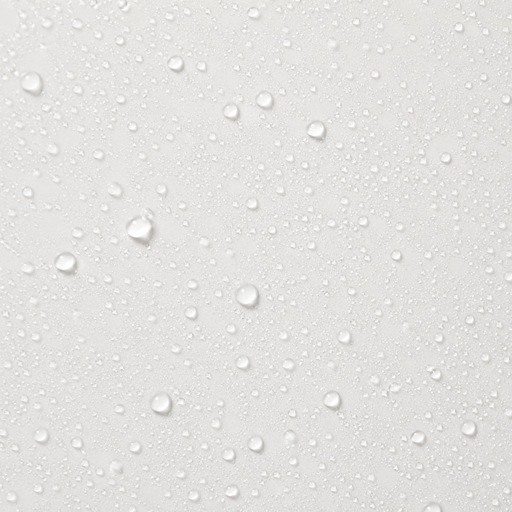 A close-up of a light gray or off-white textured surface covered with small and large clear water droplets.
