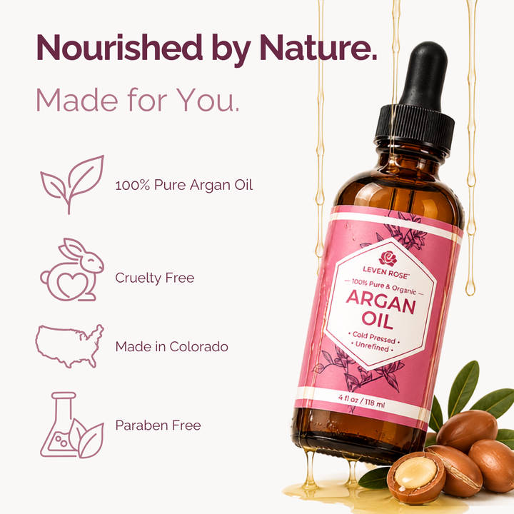 An amber glass dropper bottle of Leven Rose Argan Oil with a pink label, shown on a light beige background with marketing text and icons about pure argan oil, cruelty-free status, Made in Colorado, and paraben-free quality. Argan nuts and honey are pictured around the bottle.