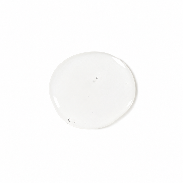A single glossy, translucent clear gel or liquid droplet centered on a solid white background.