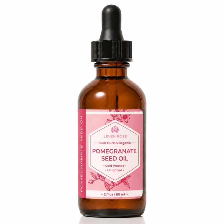 A 2 fl oz amber glass dropper bottle of Levain Rose Pomegranate Seed Oil with a pink label and black dropper cap, set against a clean white background.