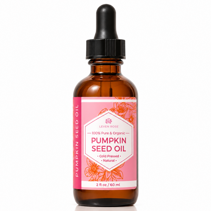 A 2 fl oz amber glass dropper bottle of Leaven Rose Pumpkin Seed Oil with a pink label and black dropper cap, shown on a white background with a soft reflection.