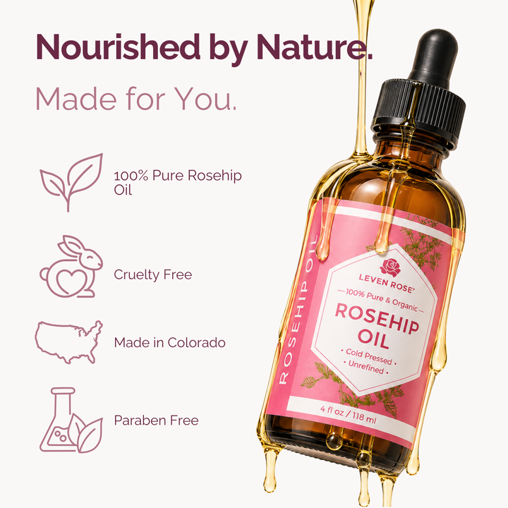 A bottle of Leven Rose Rosehip Oil with a black dropper cap, featuring a pink label and golden oil dripping from the top and bottom. The background is a very light off-white with marketing text and icons highlighting key product attributes.