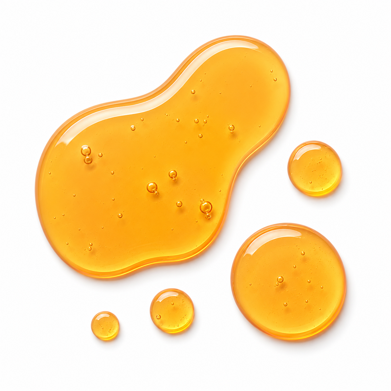 Golden translucent honey-like droplets and a larger irregular puddle on a clean white background.