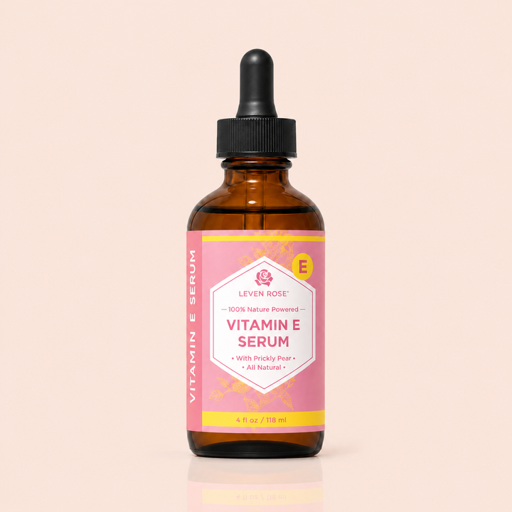 Vitamin E serum bottle with pink label on a beige background